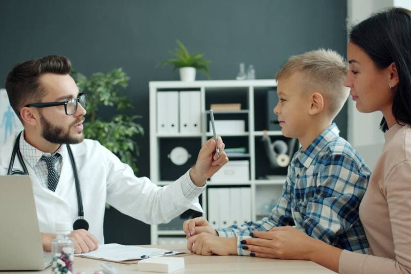 A doctor with a child and parent in a friendly consultation
