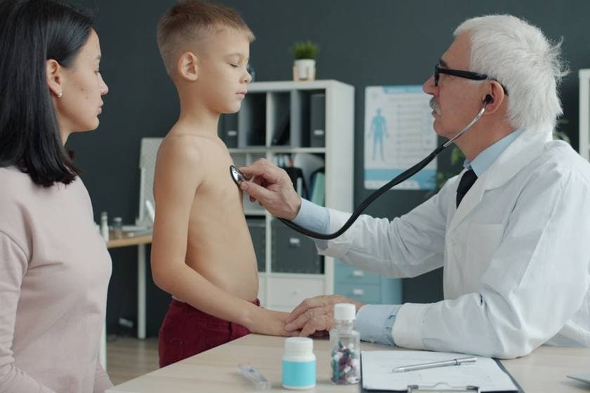 A consultant paediatrician gently examining a child